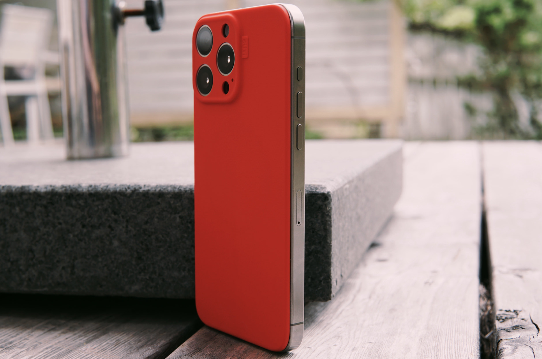 Bild zeigt das iPhone 15 Pro Max mit einer roten PhoneBack-Rückseite.