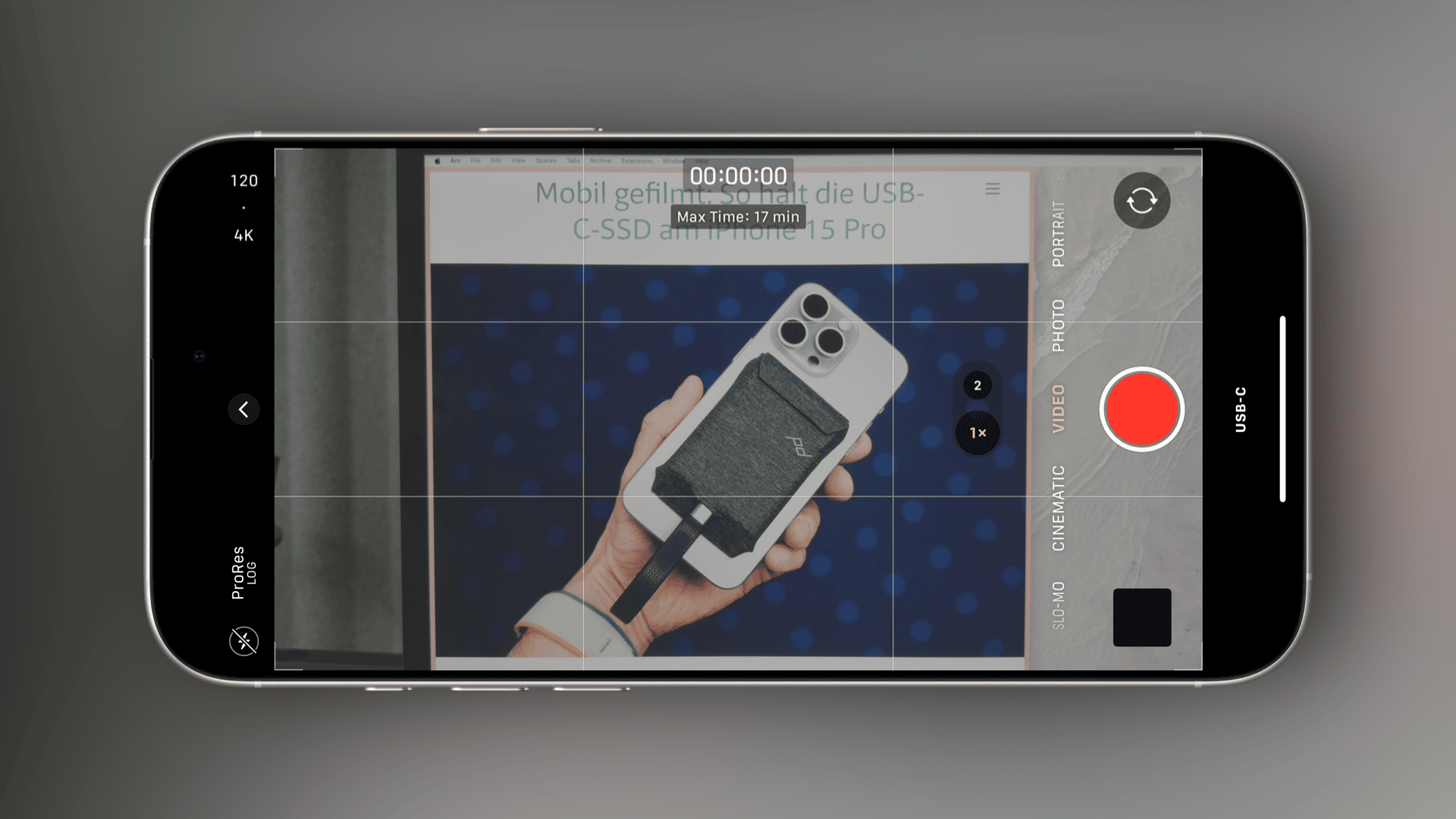 Das Bild zeigt ein iPhone, das im Videomodus aufnimmt. Auf dem Bildschirm ist eine Hand zu sehen, die ein Gerät mit USB-C-Anschluss hält. Die Aufnahmezeit ist auf 17 Minuten begrenzt und der ProRes-Log-Modus ist aktiviert.